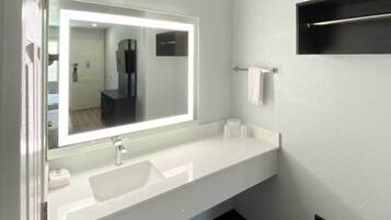 A bathroom with a white sink, a mirror, and a towel rack.