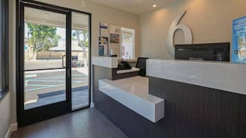 A reception area with a glass door entrance, a reception desk, and a large number '6' sign on the wall.