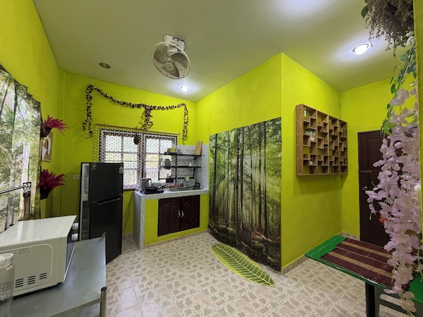 A kitchen with a refrigerator, sink, and a microwave.