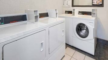 A laundry facility with a front-loading washing machine and a dryer, equipped with digital control panels.