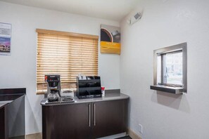 A kitchenette with a coffee maker, a microwave, and a small window with a view.