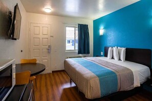 Una habitación de hotel con cama, escritorio y silla.