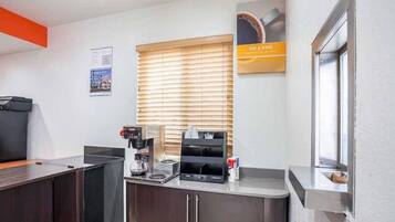 A kitchenette with a coffee machine, a toaster, and a microwave.