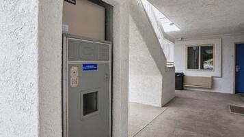 A building entrance with a metal door, a staircase, and a window.