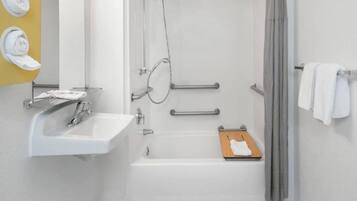 A bathroom with a white sink, a shower, and a towel rack.