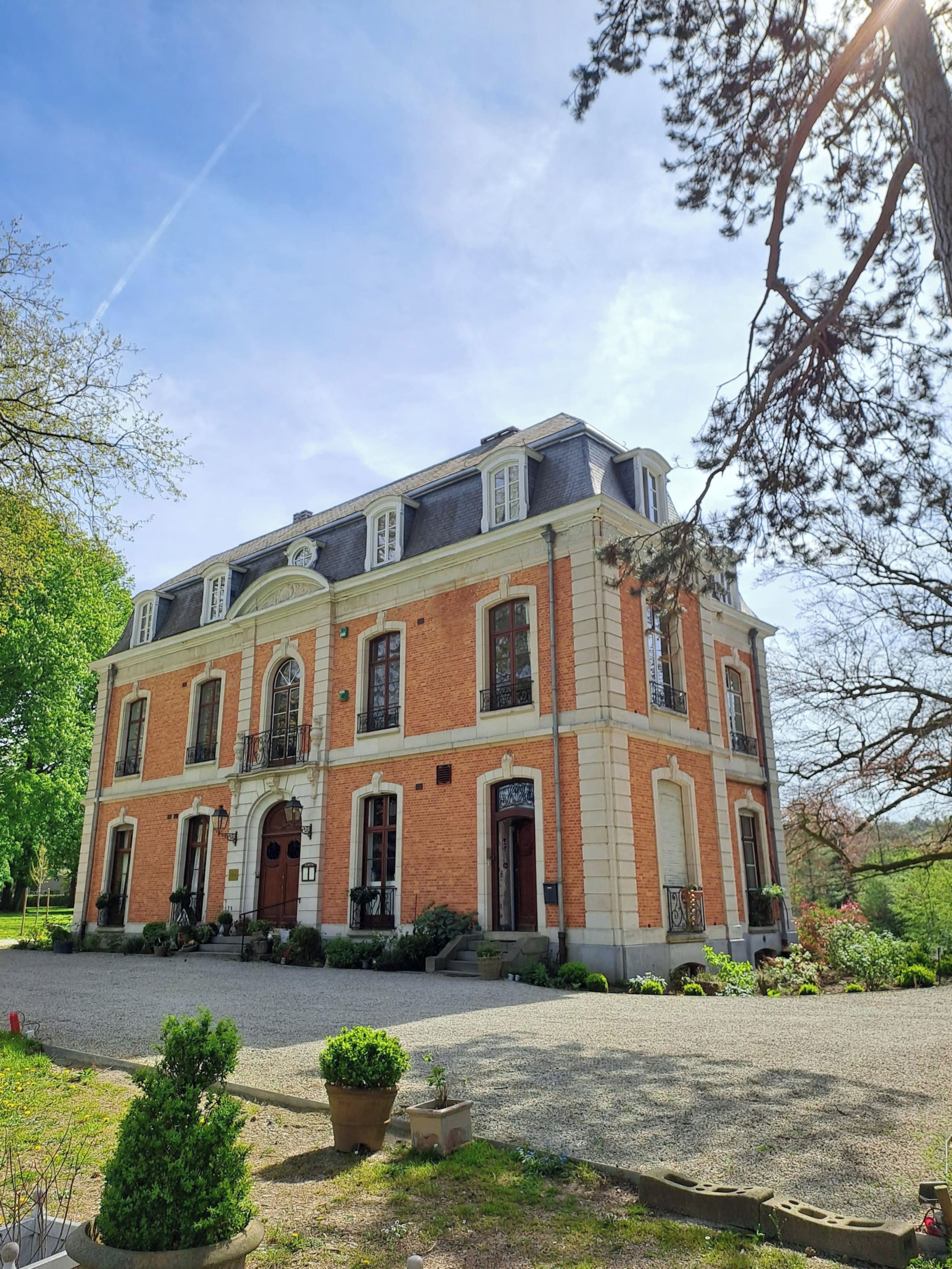 A two-story building with a symmetrical facade, large windows, and a central entrance.