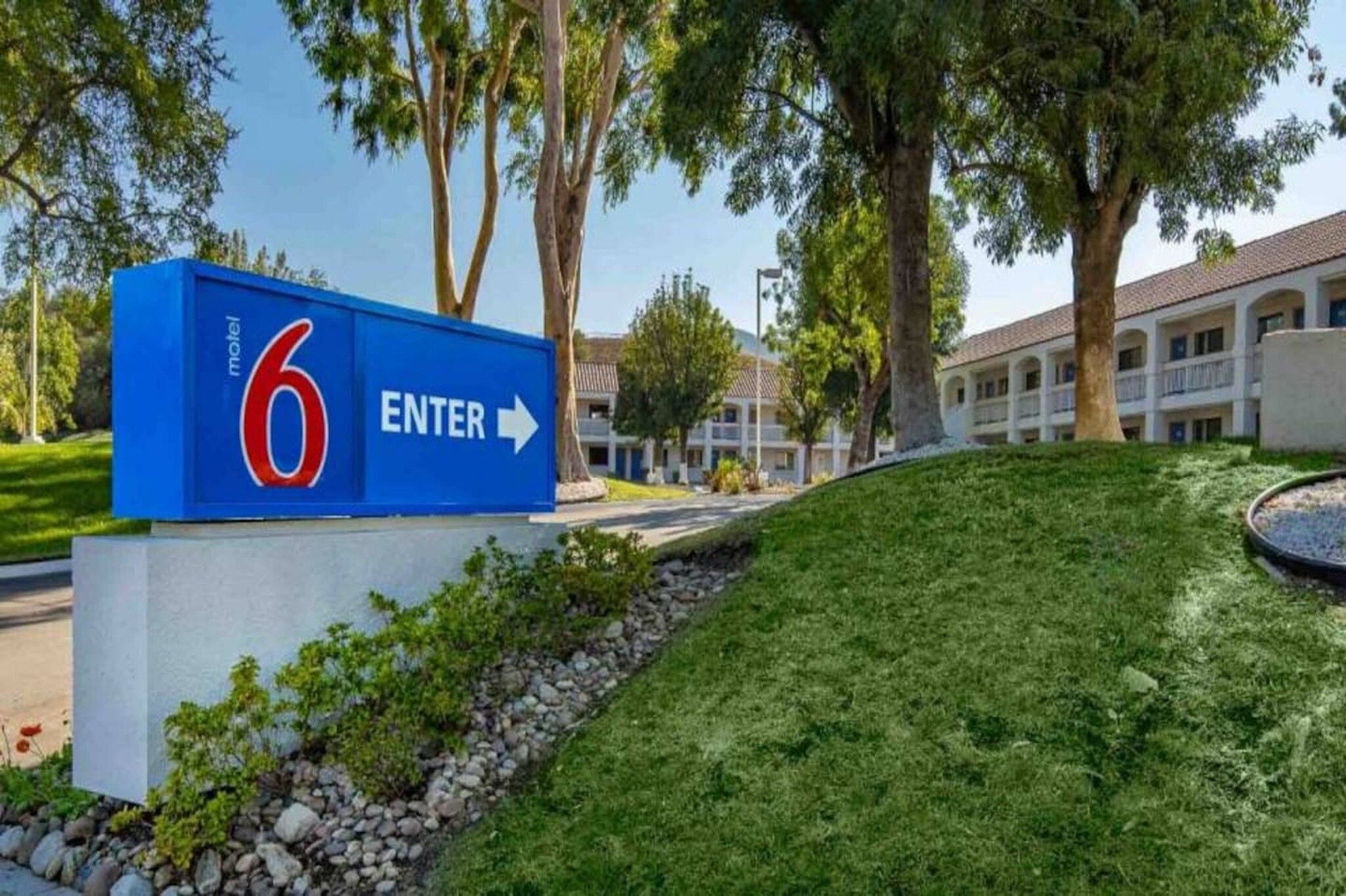A motel sign with the number 6 and an arrow pointing right, indicating the direction to enter.