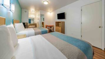 A hotel room with two beds, a desk, a chair, a television, and a wardrobe.