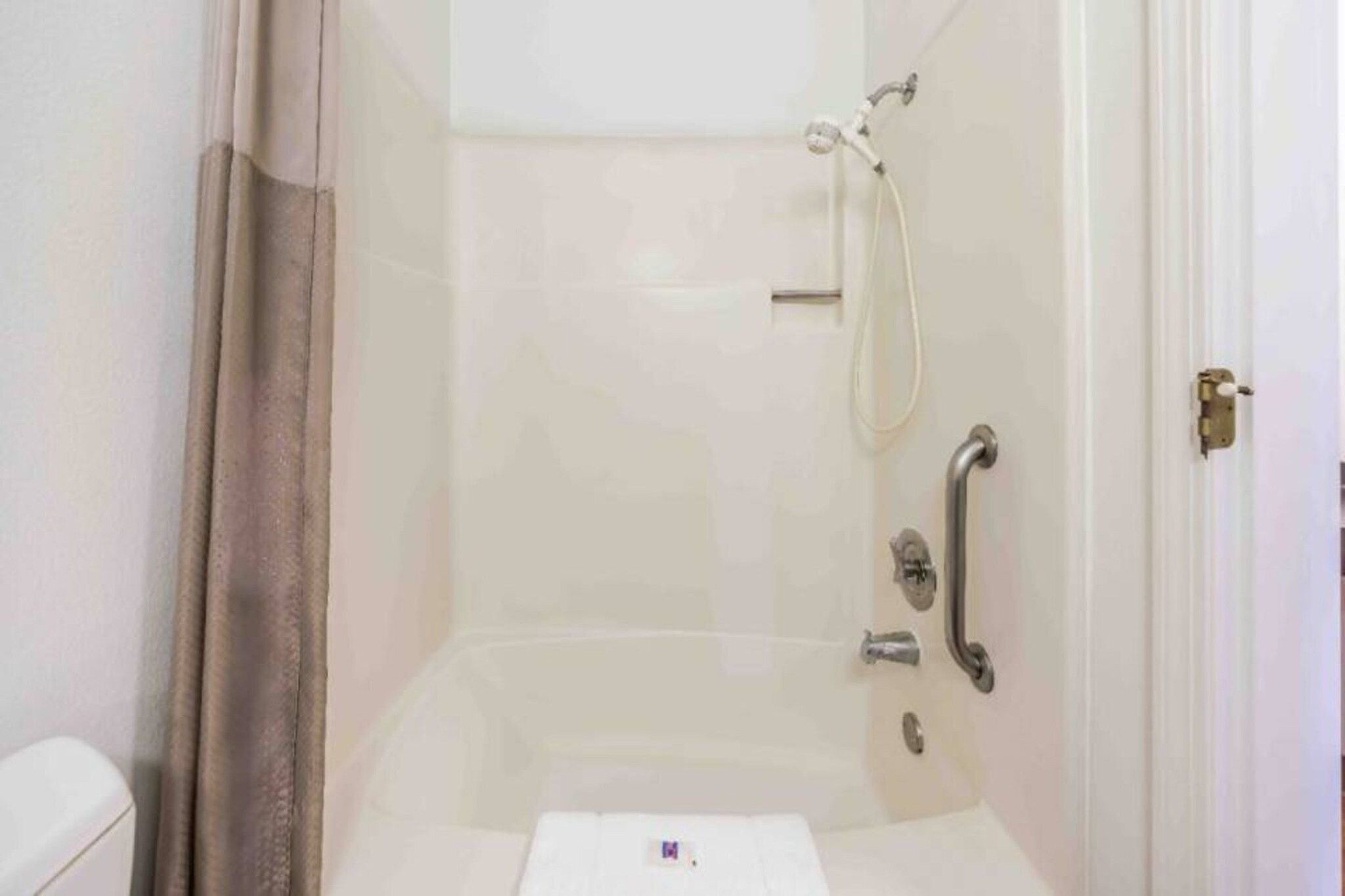Une salle de bain avec une douche, des toilettes et une porte.