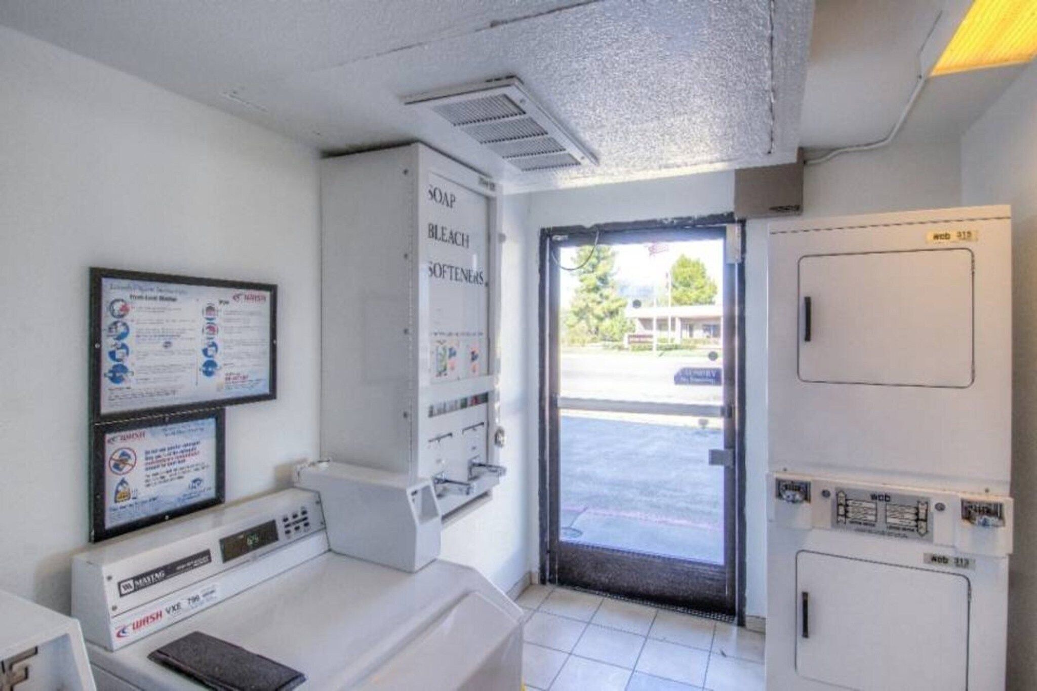 A room with a washing machine, a dryer, and a door leading outside.