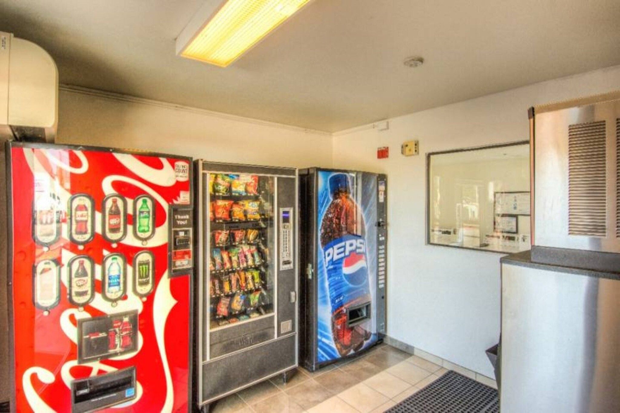 Three beverage vending machines with various drink options.
