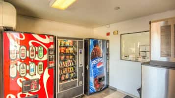Three beverage vending machines with various drink options.