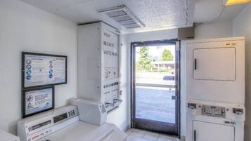 A room with a washing machine, a dryer, and a door leading outside.