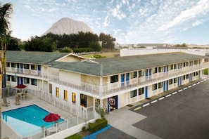 A motel with a swimming pool, multiple balconies, and a mountain in the background. - Morro Bay 2 Full Beds | Micfridg (Morro Bay)