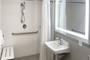 A bathroom with a shower, a handrail, a sink, and a mirror. - Morro Bay 2 Full Beds | Micfridg (Morro Bay)