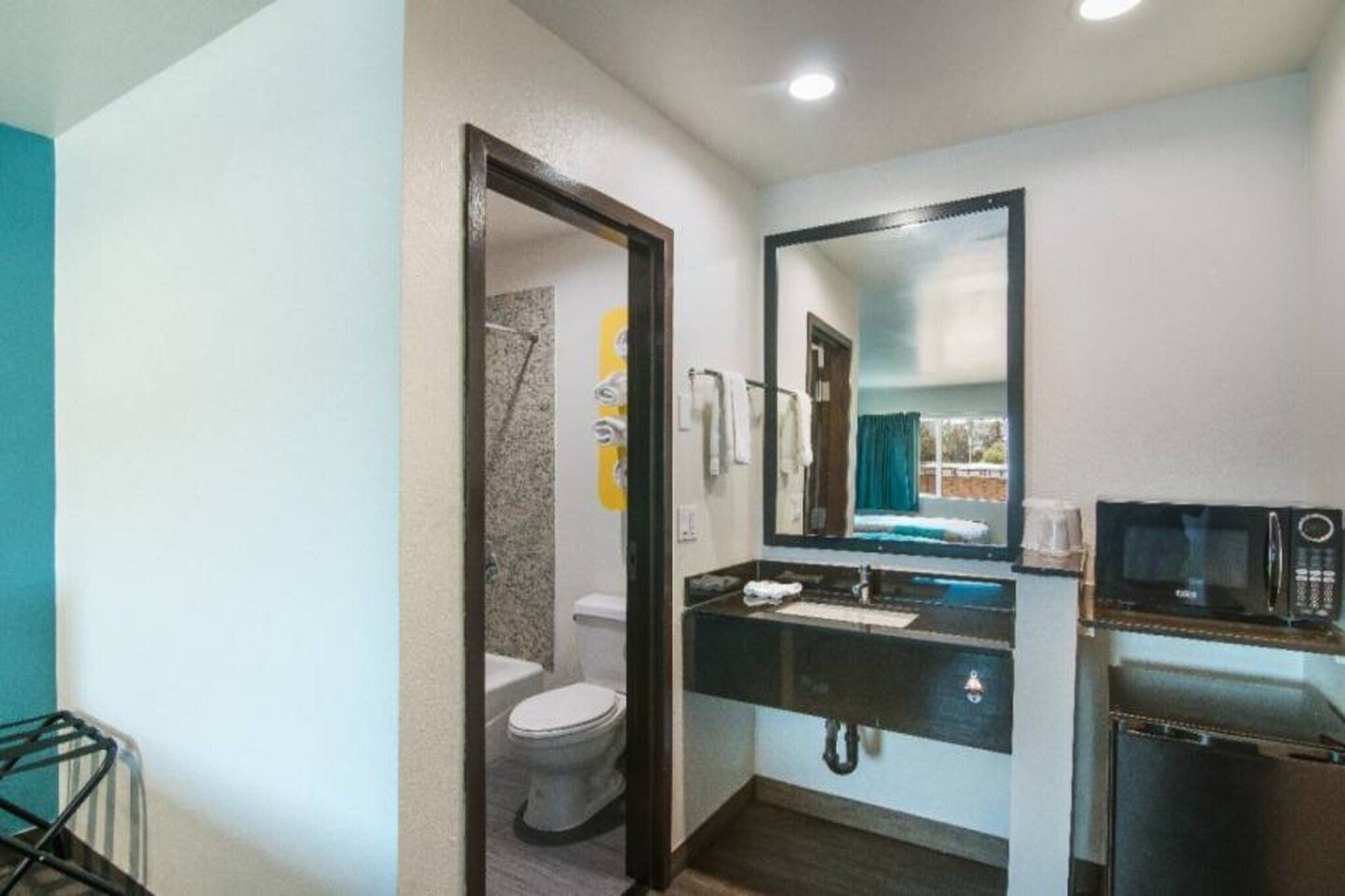 A compact bathroom with a toilet, sink, and mirror.