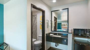 A compact bathroom with a toilet, sink, and mirror.