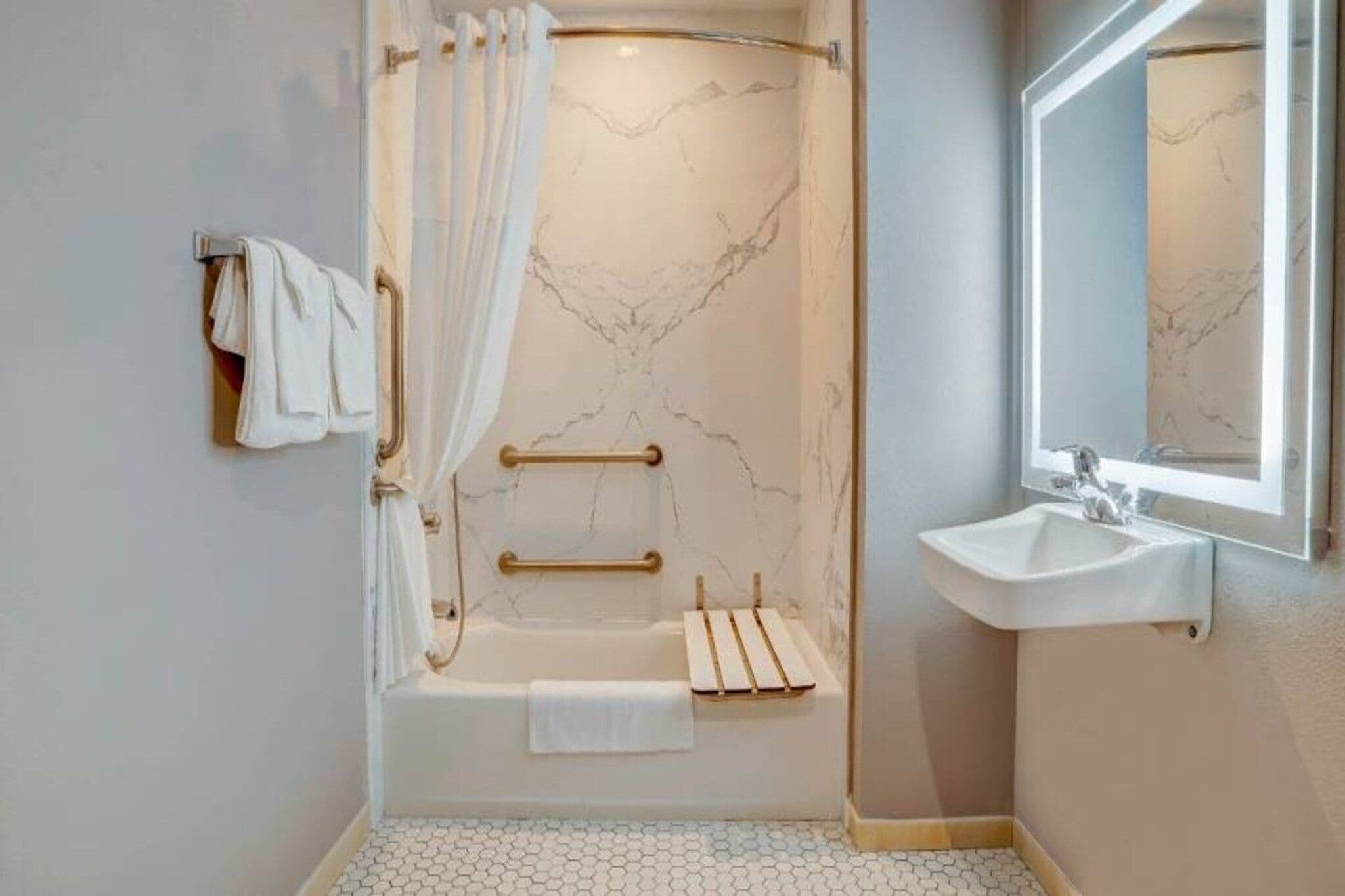 A modern bathroom with a bathtub, a shower, and a sink.