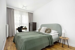 Ein modernes Schlafzimmer mit Bett, Schreibtisch und Stuhl.
