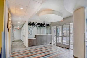 A reception area with a counter, a patterned carpet, and a glass door leading outside.