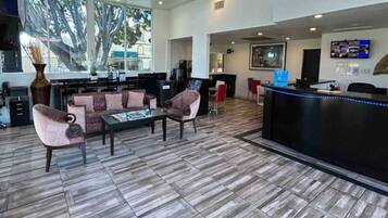 A reception area with a counter, seating, and a view of the outdoors.