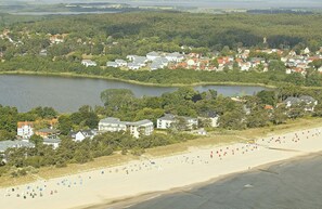 An aerial view of a coastal town with a beach, houses, and a lake. - Vrbo Property (Bansin (Seebad))