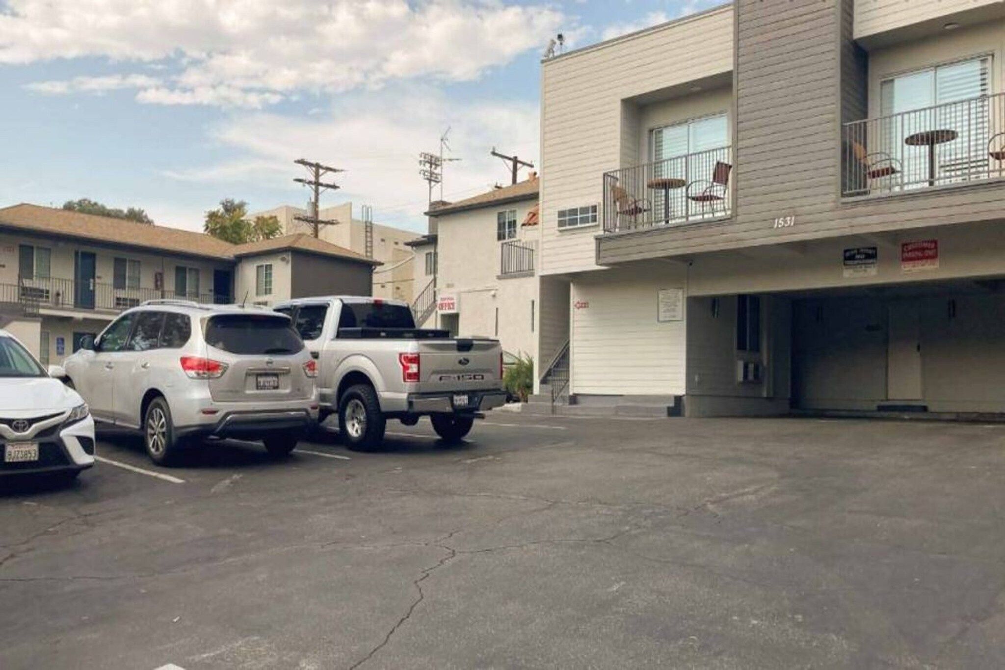 A parking lot with a white SUV and a pickup truck.