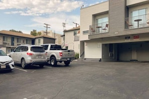 Een parkeerplaats met een witte SUV en een pick-up truck.