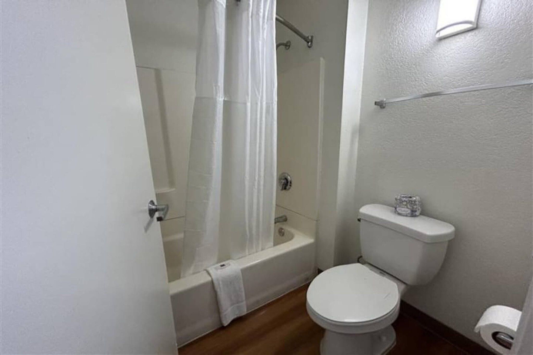 A bathroom with a bathtub, toilet, and shower curtain.