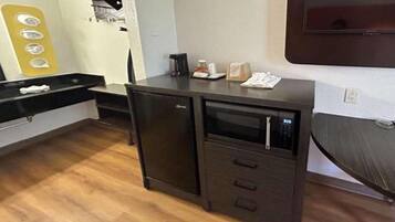 A compact kitchenette with a microwave, a small refrigerator, and a sink.