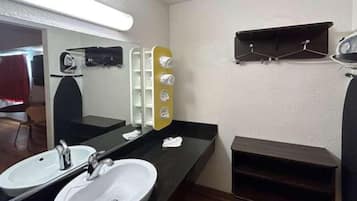 Een badkamer met twee wastafels, een spiegel en een handdoekhouder.