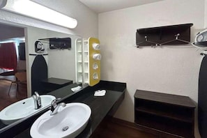 Een badkamer met twee wastafels, een spiegel en een handdoekhouder.