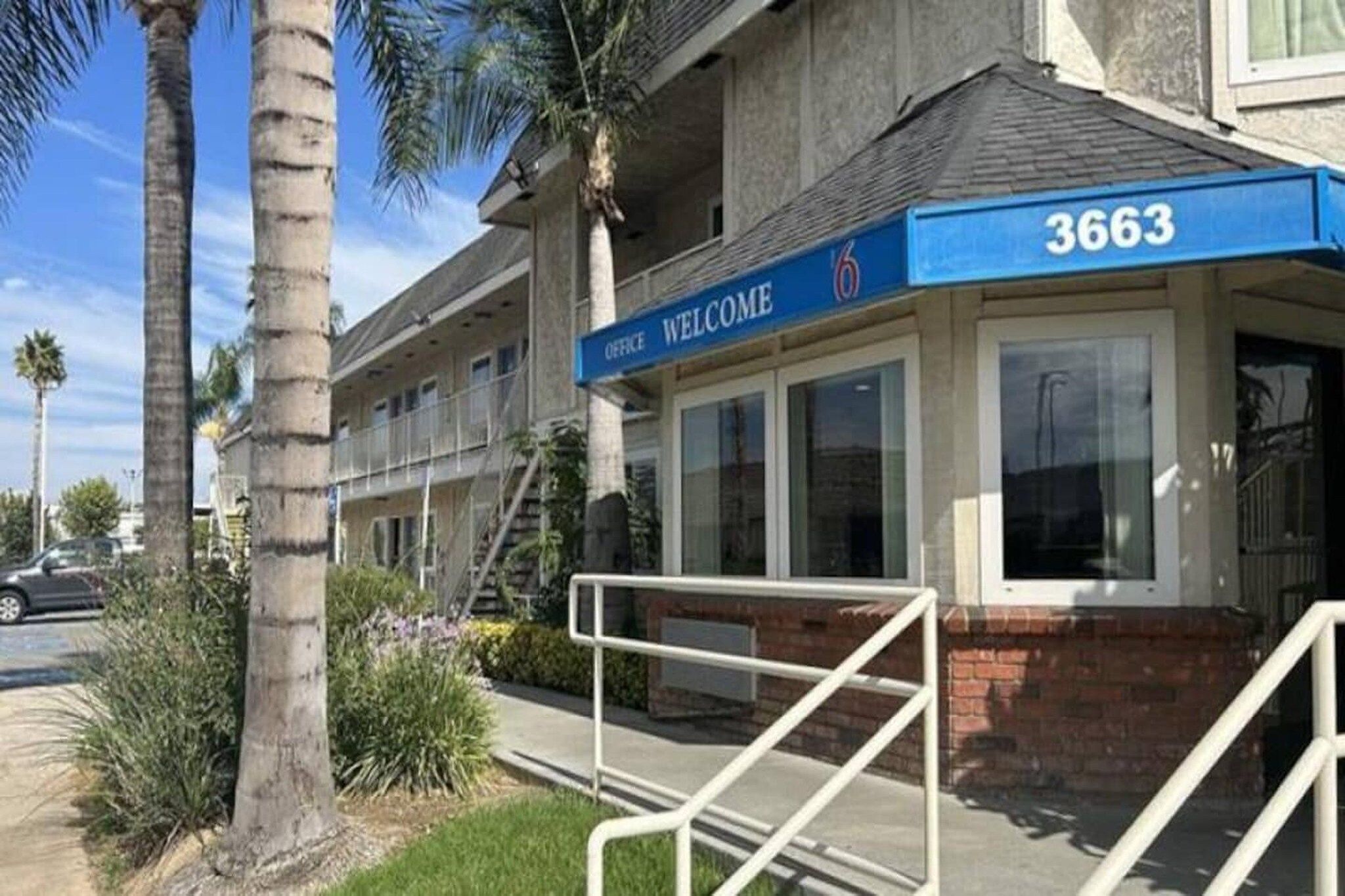 A building with a blue awning displaying the number 3663 and a sign that reads 'OFFICE WELCOME'.