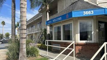 A building with a blue awning displaying the number 3663 and a sign that reads 'OFFICE WELCOME'.