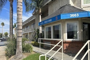 Un edificio con toldo azul que muestra el número 3663 y un cartel que dice 'OFFICE WELCOME'.