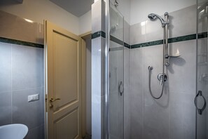 Ein modernes Badezimmer mit Duschkabine aus Glas, Toilette und einer Tür mit Messinggriffen.