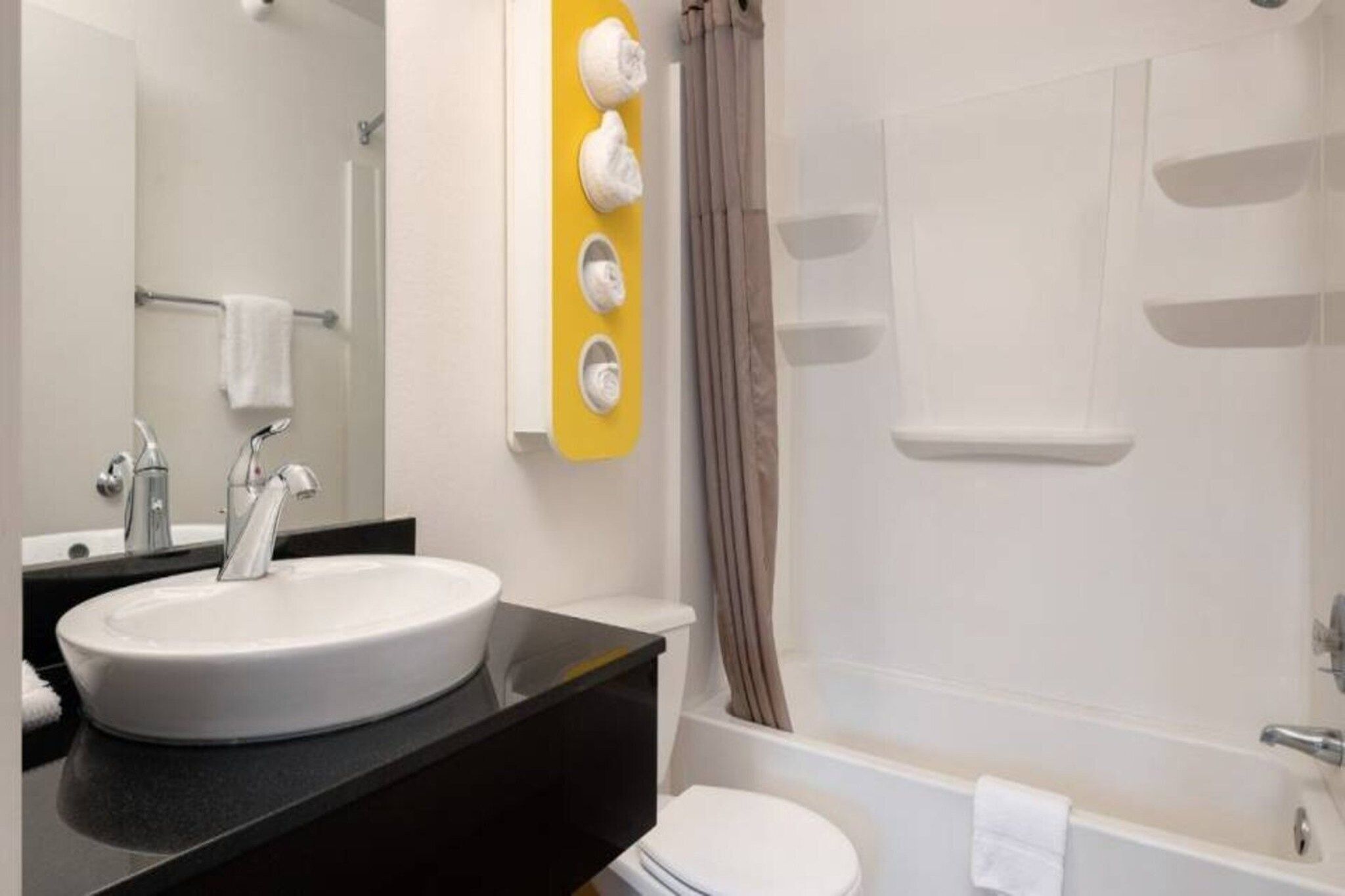 Un baño con lavabo, espejo y ducha.