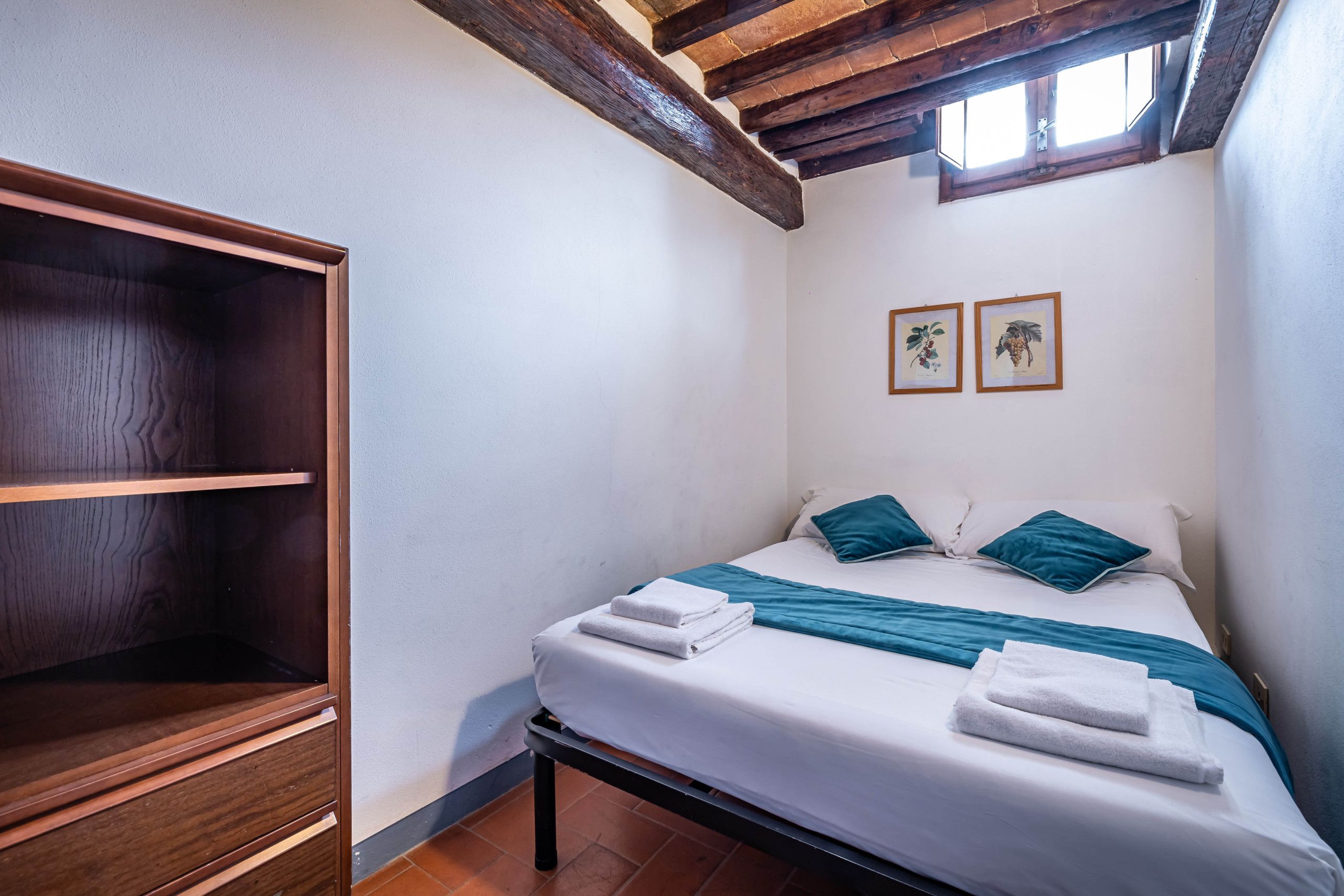 Ein Schlafzimmer mit einem Bett, Kissen und einem Holzschrank.