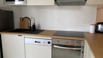 A modern kitchen with a microwave, dishwasher, and oven.