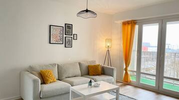 A modern living room with a sofa, a coffee table, and a floor lamp.