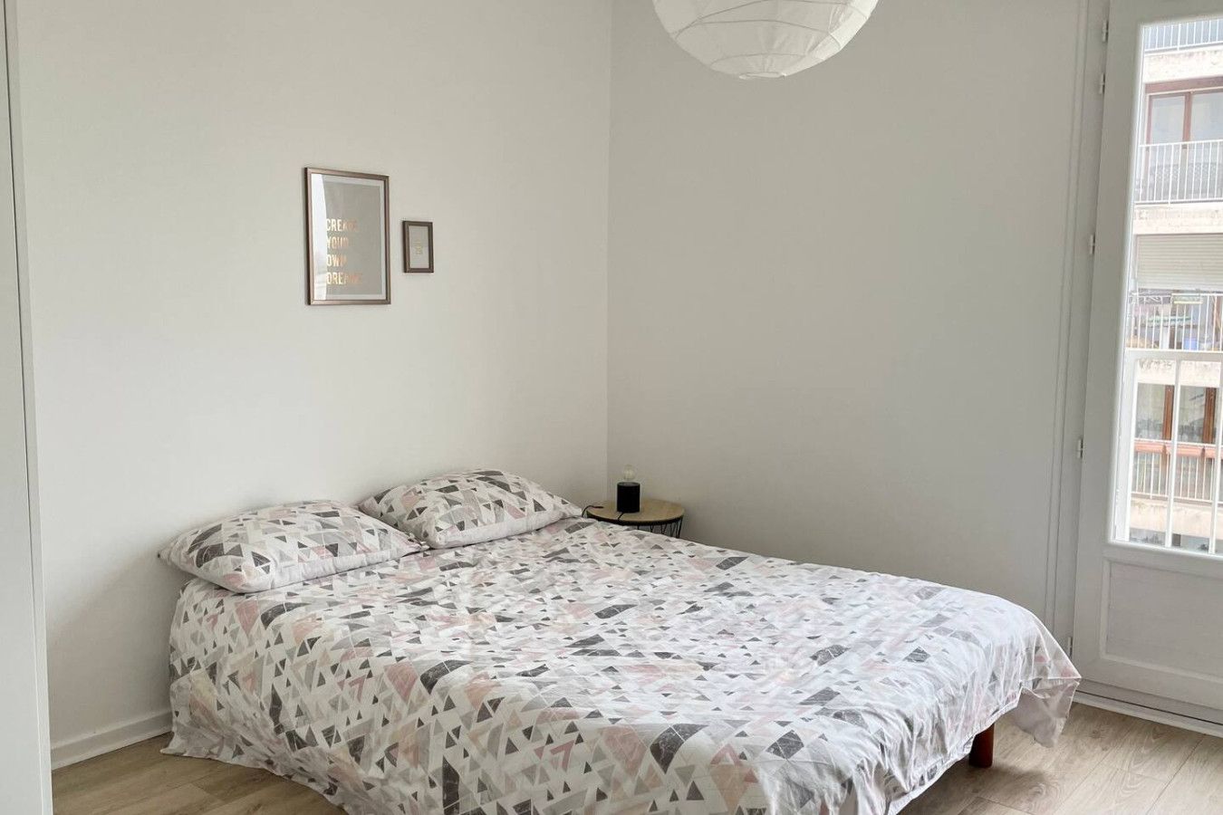 Ein Schlafzimmer mit einem Bett, einem Nachttisch und einem Fenster.