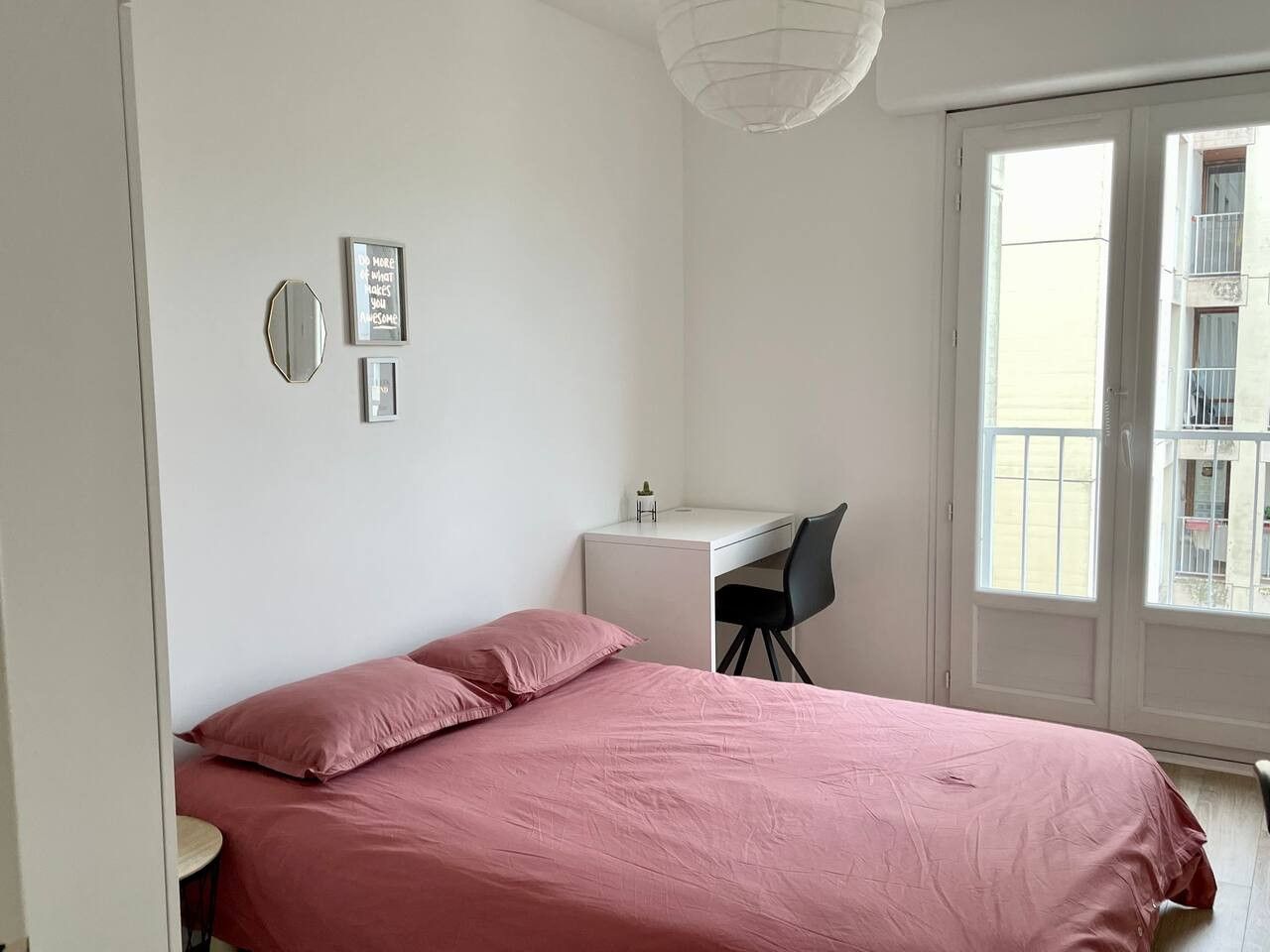 A bedroom with a bed, a desk, and a chair.