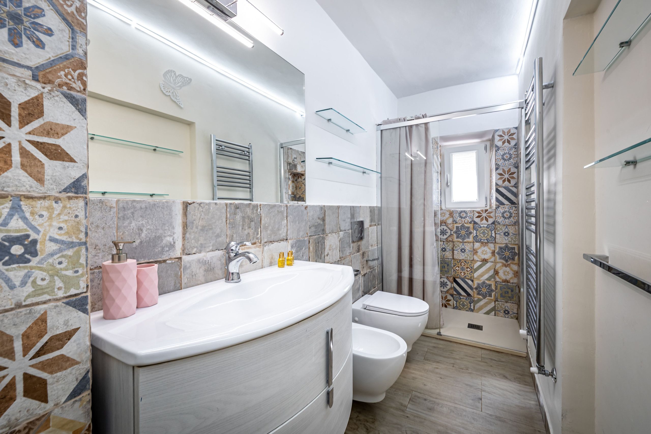 A bathroom with a sink, toilet, and shower area.