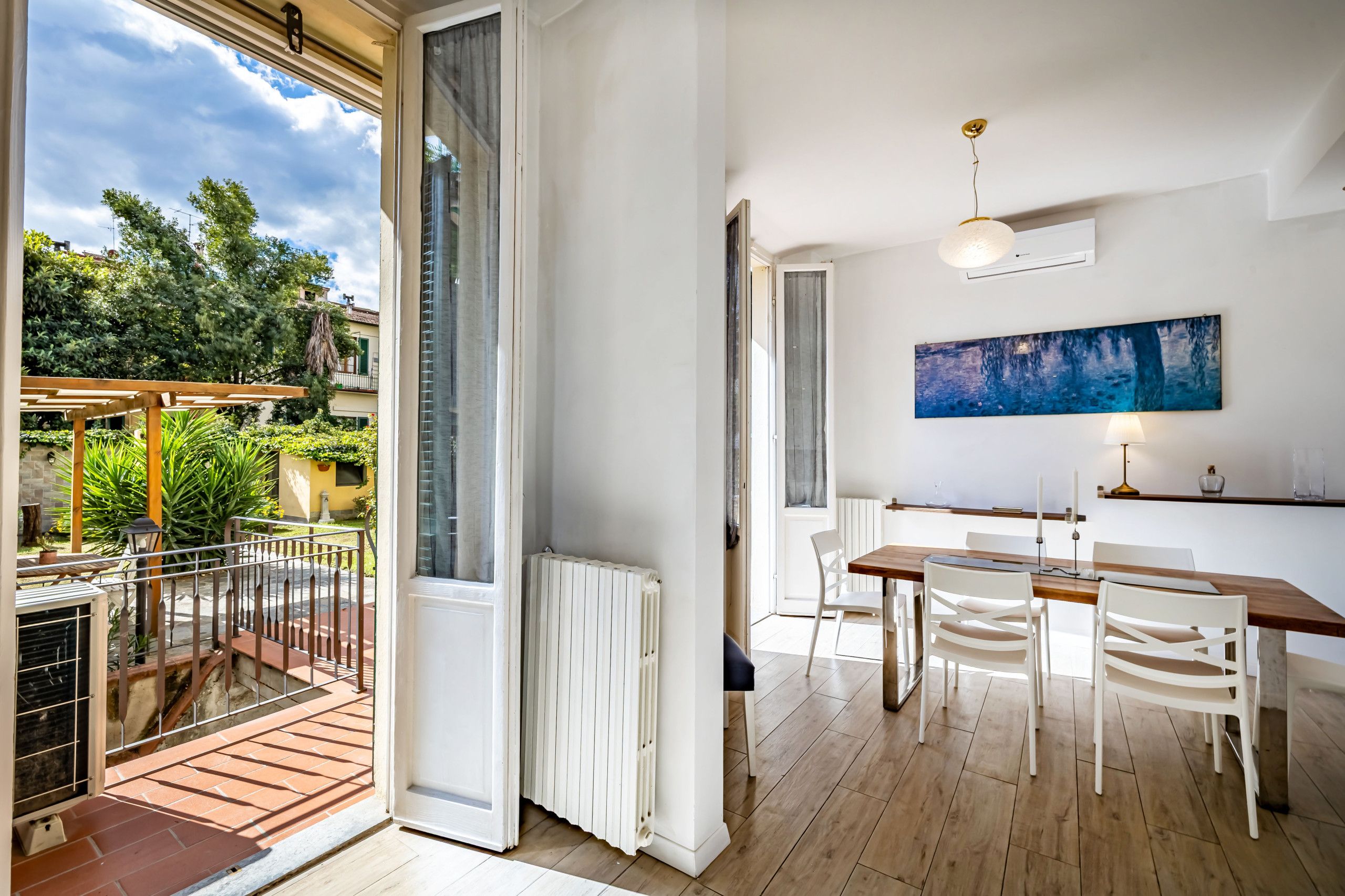Ein modernes Interieur mit Essbereich, einem großen Fenster und Blick ins Freie.