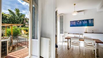 Ein modernes Interieur mit Essbereich, einem großen Fenster und Blick ins Freie.