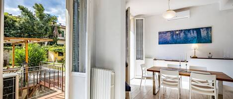 A modern interior with a dining area, a large window, and a view of the outdoors.