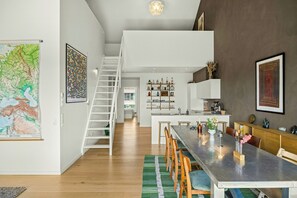 Ein modernes Interieur mit Treppe, Essbereich, Küche und Wohnbereich.