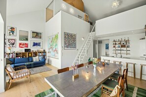 A modern interior with a dining area, kitchen, and living space. - Østerbro flat with views over Copenhagen (København)