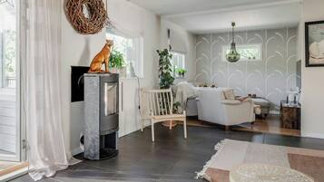 En moderne stue med pejs, siddeområde og pynt.