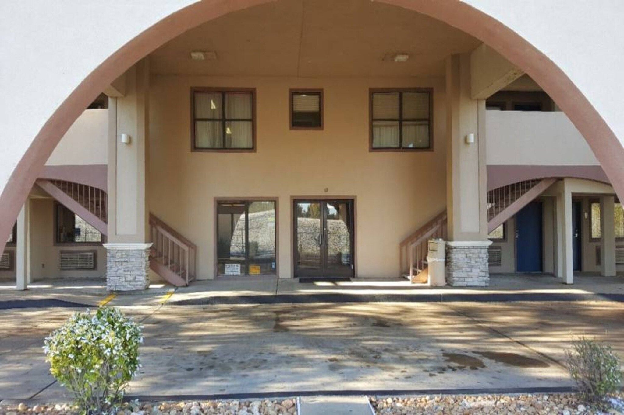 A building with a central entrance, two staircases on either side, and a symmetrical facade.